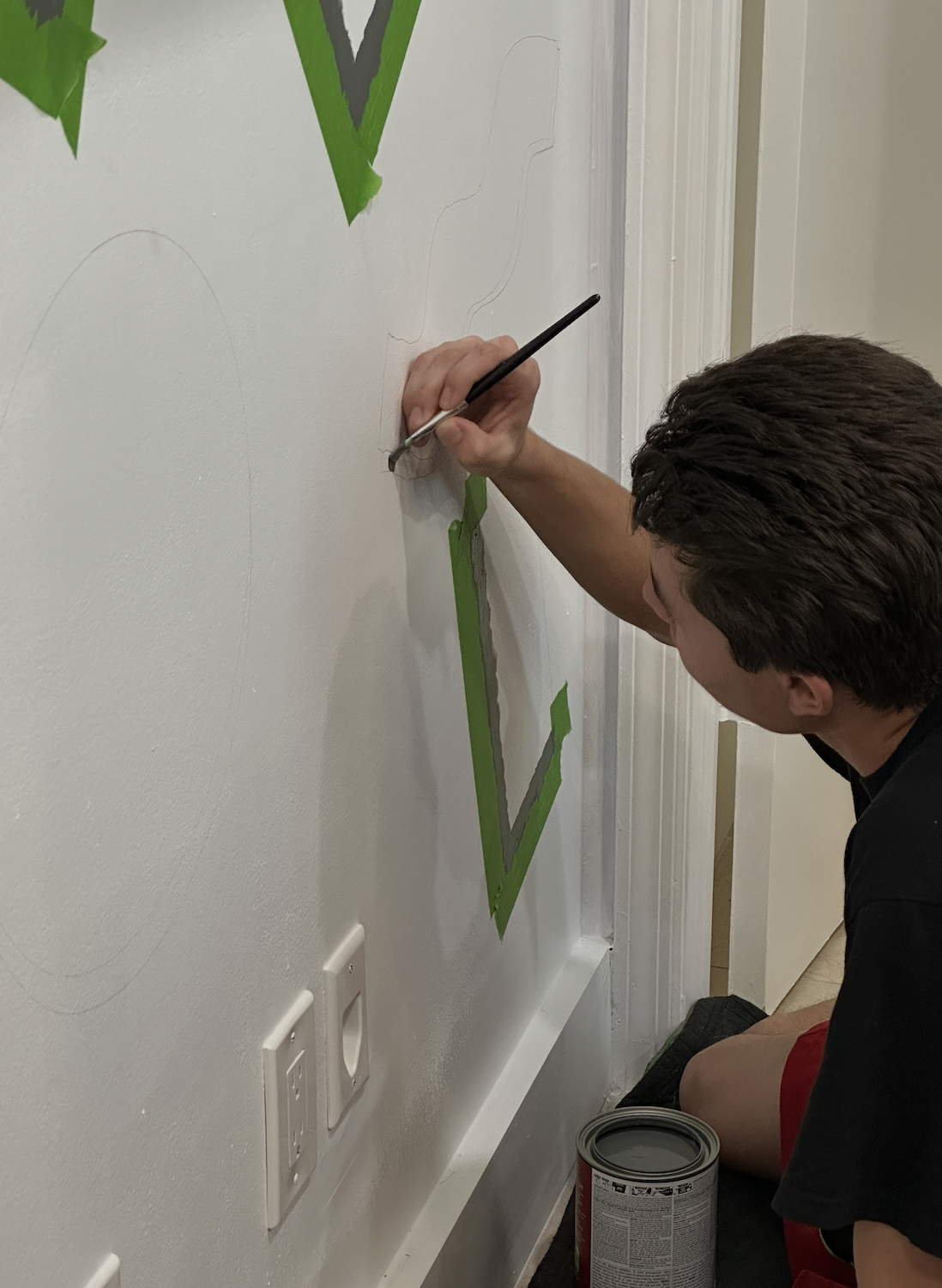 Michael painting the geometric shapes onto the wall by hand