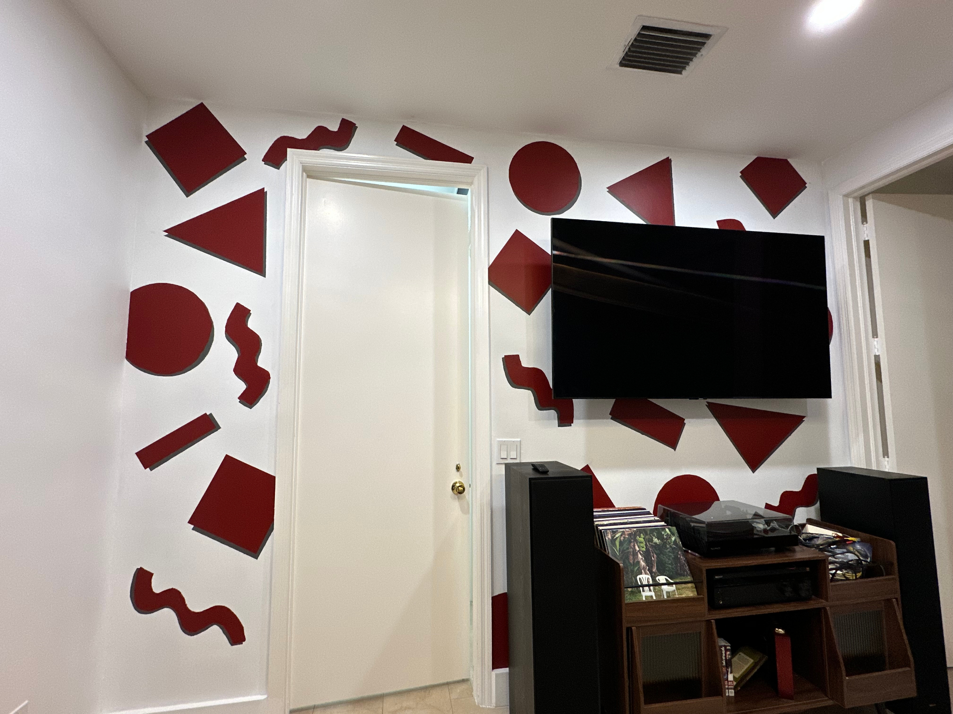 Hand-painted Memphis-style red geometric mural on the wall of Michael's room